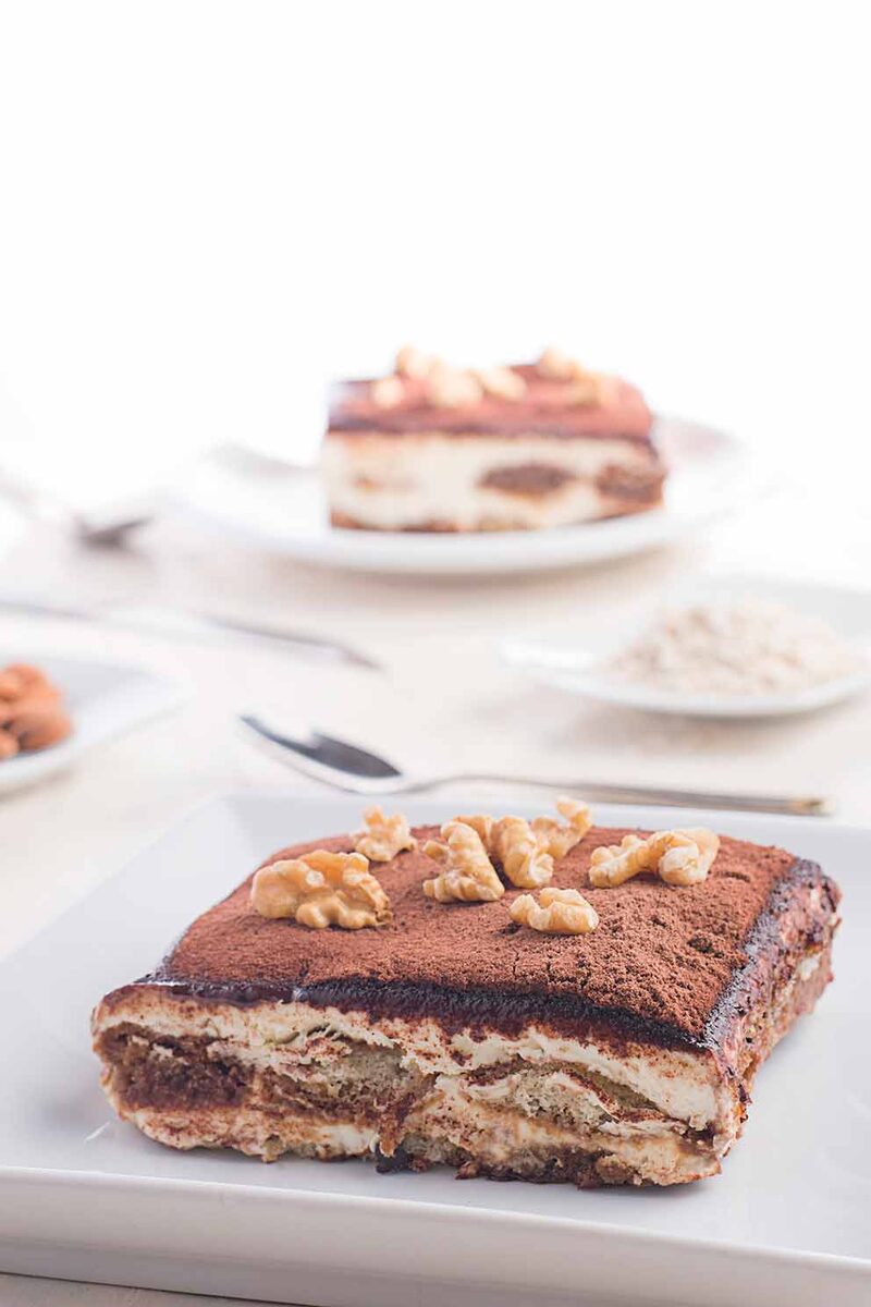 Slice of walnut tiramisu on a white plate, light and airy